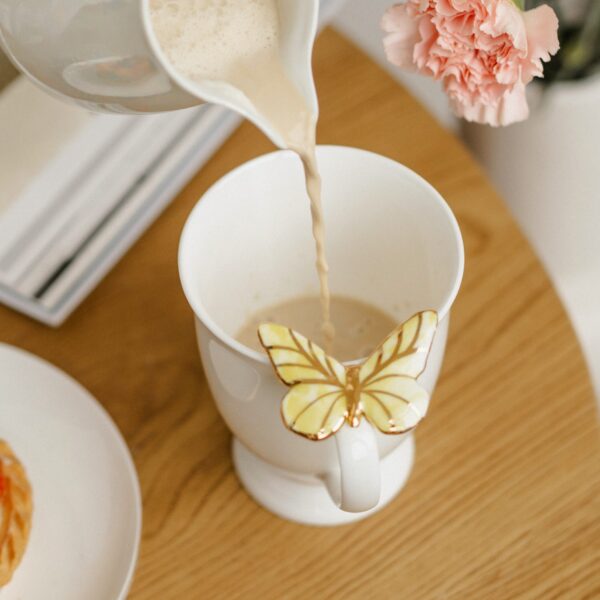 Porcelianinis puodelis su geltonu drugeliu