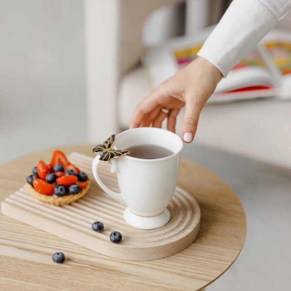 Porcelianinis puodelis su juodu drugeliu