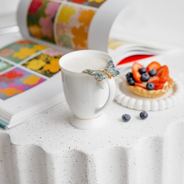 Porcelianinis puodelis su mėlynu drugeliu