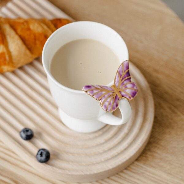 Porcelianinis puodelis su violetiniu drugeliu